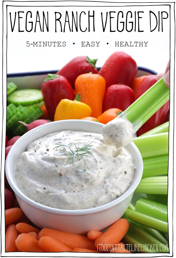 a bowl filled with ranch dip surrounded by carrots and celery