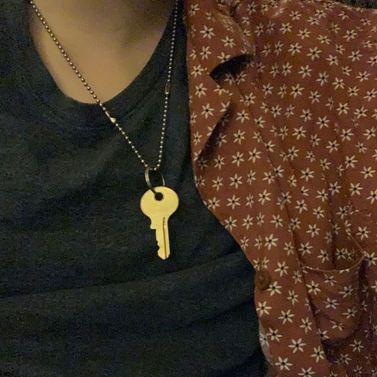 a person wearing a necklace with a key on it