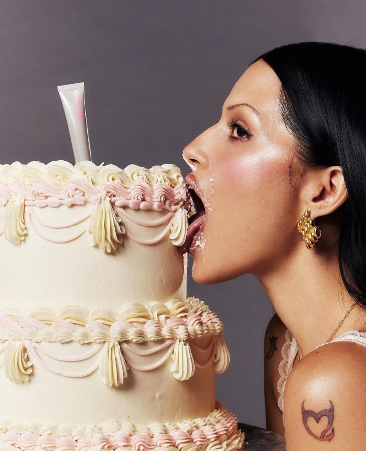 a woman is blowing out the icing on her cake