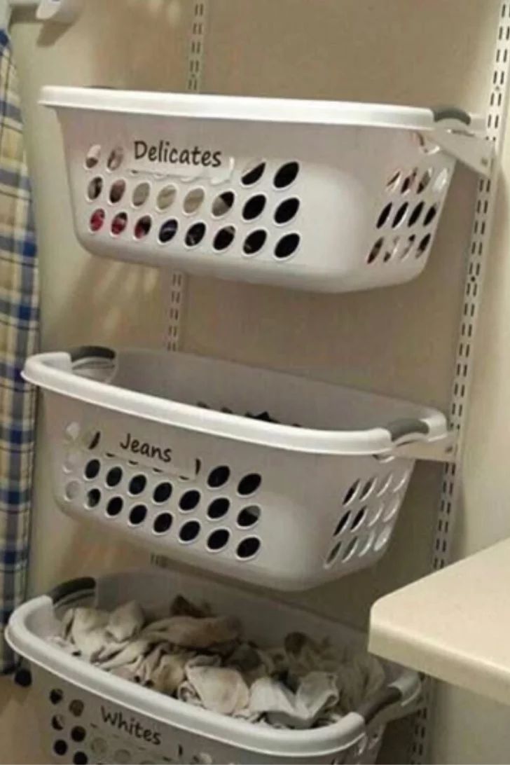 three laundry baskets stacked on top of each other next to a sink in a bathroom