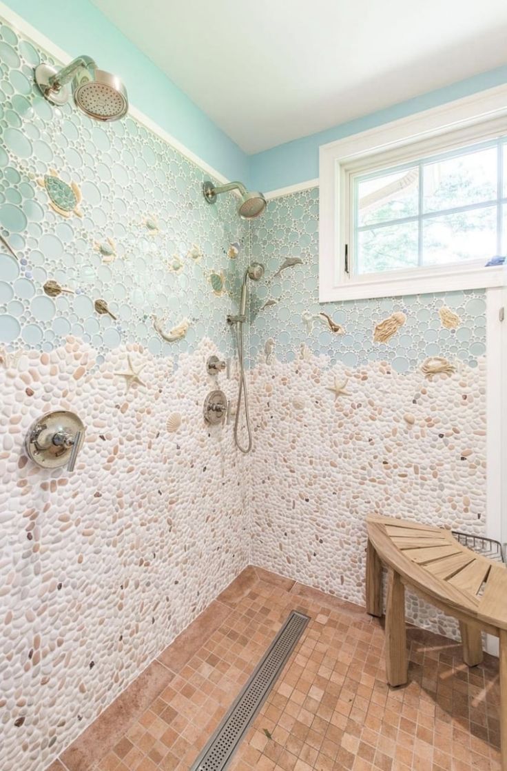 a bathroom with a bench, shower head and tiled walls in the corner next to a window