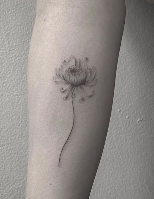 a woman's leg with a flower tattoo on the left side of her arm