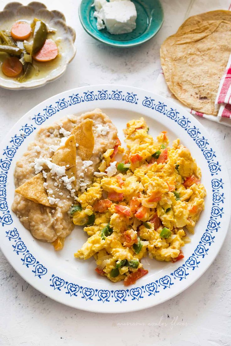 a plate with eggs, tortillas and other food on it