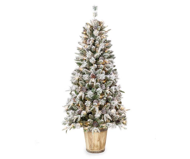 a small christmas tree in a pot with snow on the top and bottom, standing upright