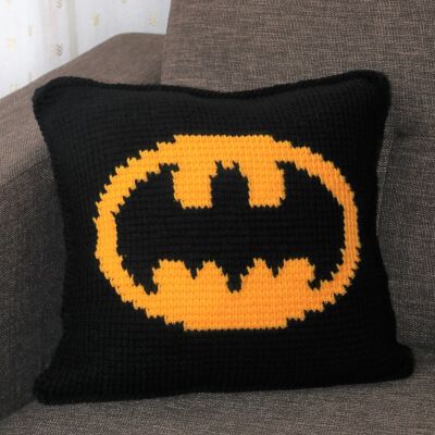 a crocheted batman pillow sitting on top of a couch