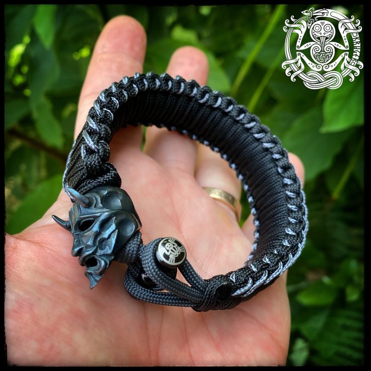 Exquisitely carved brass bead of a Japanese Oni demon in deep blackened brass. .Bracelet in black with gray accents commonly associated with Oni folklore. Other colors available on request. Traditional Black Adjustable Bracelets, Traditional Adjustable Black Bracelets, Black Spiritual Jewelry With Antique Finish, Traditional Black Adjustable Bracelet, Artisan Black Bracelet For Gift, Artisan Black Festival Bracelet, Black Engraved Wristband Bracelet, Handmade Symbolic Black Beaded Bracelets, Adjustable Black Oxidized Bracelet