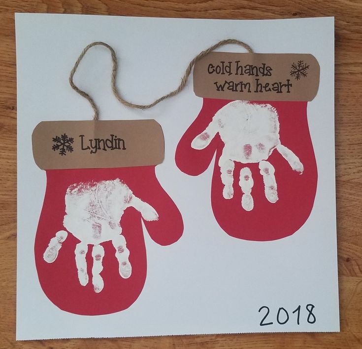 two handprinted red mitts with white hands and brown tags that say, gold baubies warm heart