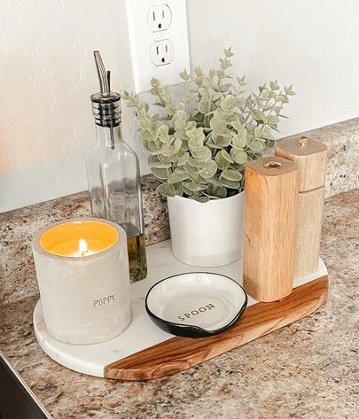 a kitchen counter with a candle, soap dispenser and other items on it