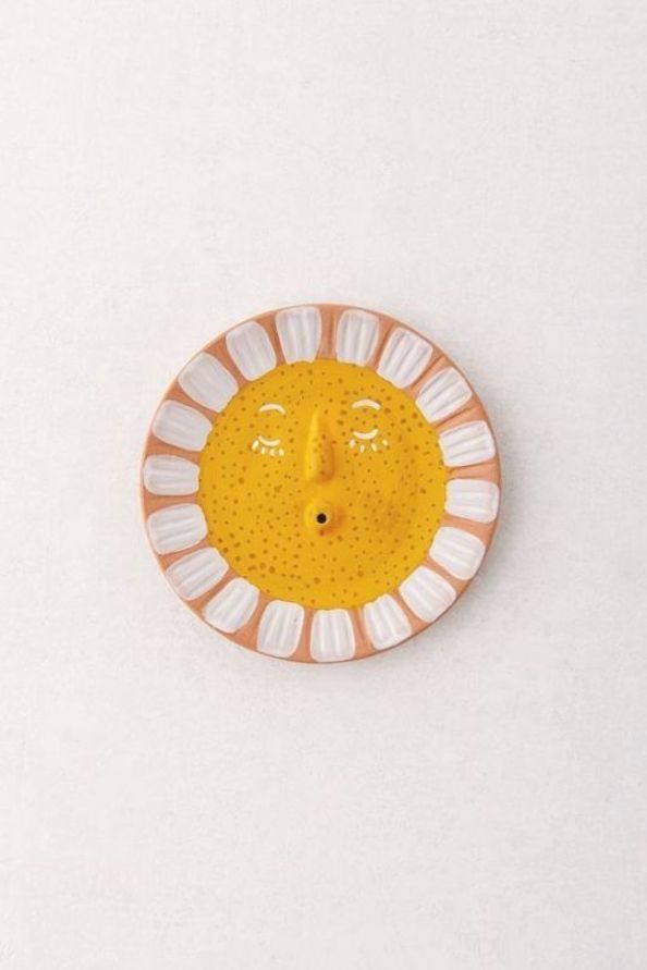 an orange and white plate with a yellow face on it's side, against a white background