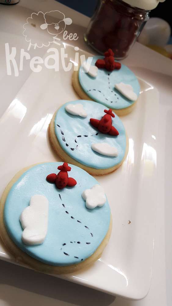 three decorated cookies sitting on top of a white plate