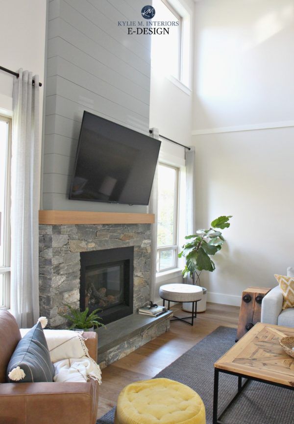 a living room filled with furniture and a flat screen tv mounted on the wall above a fire place