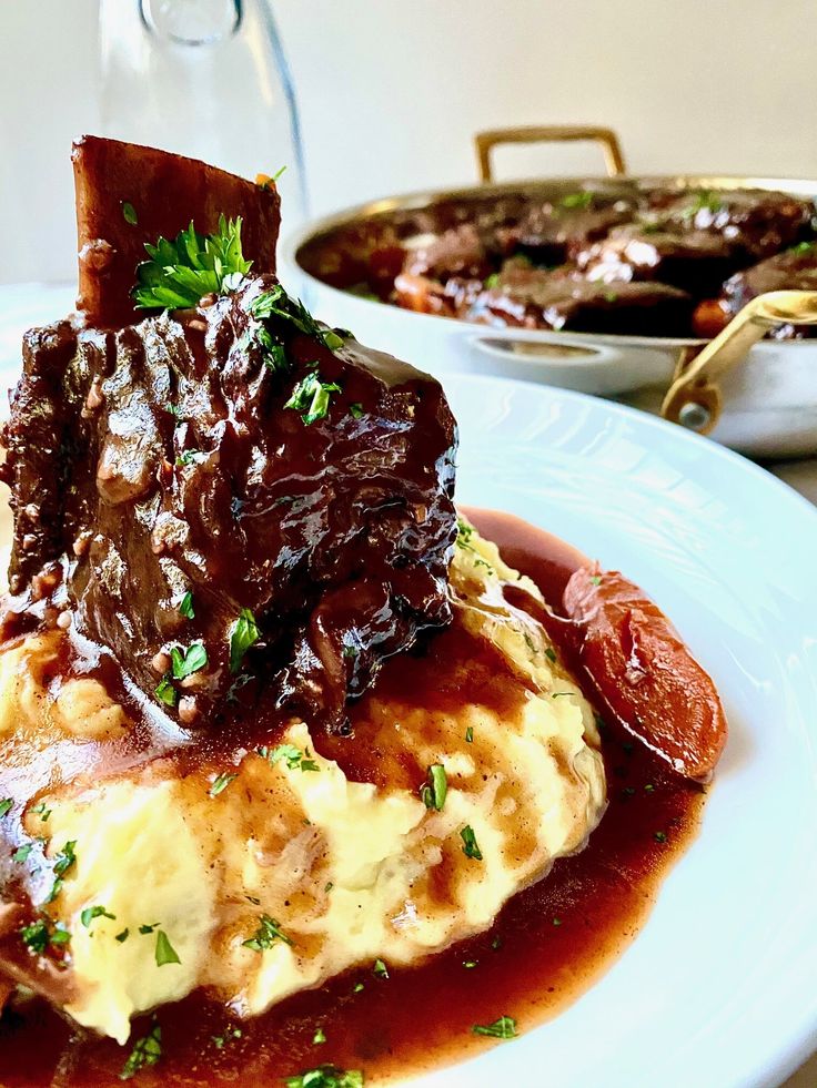 a white plate topped with meat covered in gravy