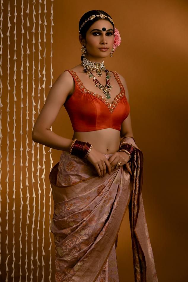 Orange pure silk blouse featuring a sweetheart neckline with intricate hand embroidery of zari, thread, sequin, and bead work, Fit: Relaxed Silk Sleeveless Blouse For Reception, Sleeveless Silk Blouse For Reception, Elegant Sleeveless Blouse With Intricate Embroidery, Sleeveless Silk Blouse With Cutdana, Elegant Sleeveless Blouse With Resham Embroidery, Elegant Sleeveless Designer Wear Blouse Piece, Elegant Sleeveless Designer Blouse Piece, Sleeveless Silk Choli With Zari Work, Sleeveless Blouse With Intricate Embroidery For Reception