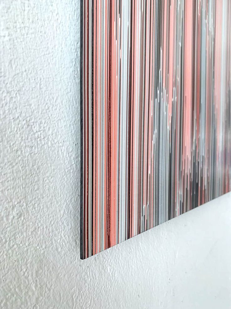 a painting hanging on the side of a white wall next to a red and blue striped piece of art