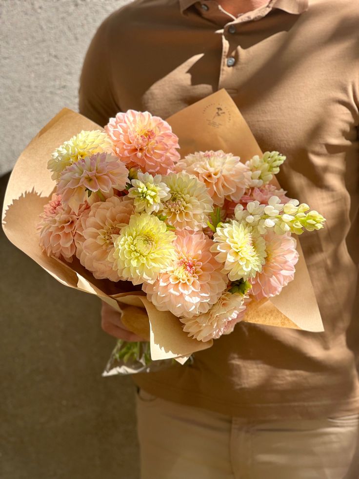 a woman holding a bouquet of flowers in her hands