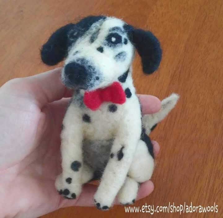 a small stuffed dog with a red bow tie on it's collar sitting in someones hand