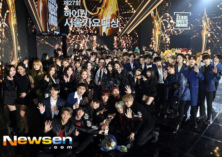 a group of people posing for a photo in front of a stage full of lights