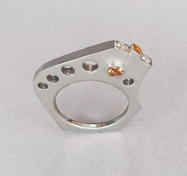 Unique modern design ring in sterling silver with two tube set topaz, one opposite each other through the ring. Diamonds and topaz set on the top of the ring. The ring fits comfortably against your pinky if worn on the ring finger and against the ring finger if worn on your pinky! Modern White Gold Topaz Jewelry, Modern Sapphire Ring With Diamond Accents, Modern White Gold Open Birthstone Ring, Modern White Topaz Diamond Ring For Gift, Modern White Topaz Diamond Ring Gift, Modern White Topaz Diamond Ring As Gift, Modern Sapphire Ring With Single Cut Diamonds For Anniversary, Modern Sterling Silver Diamond Ring For Anniversary, Modern Sterling Silver Diamond Promise Ring