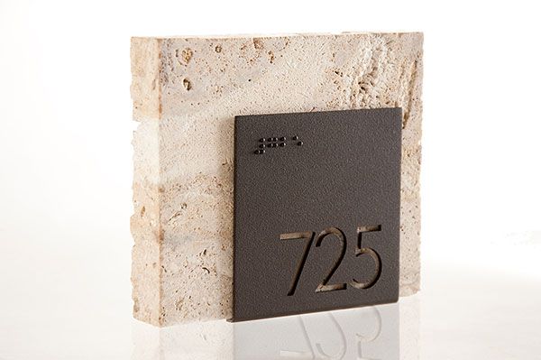 a white marble block with a black metal number twenty five on the front and bottom