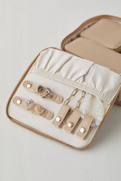 an open suitcase with several pieces of jewelry in it on a white tablecloth background