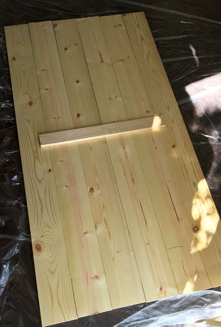 a piece of wood sitting on top of plastic covered ground next to a door frame