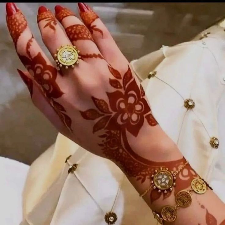 a woman's hand with henna and rings on it