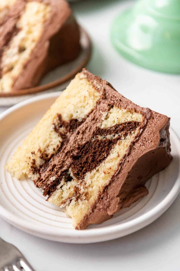 two slices of chocolate cake on white plates