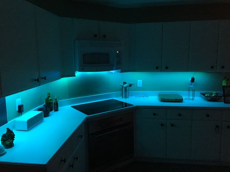 a kitchen with blue lights on the counter