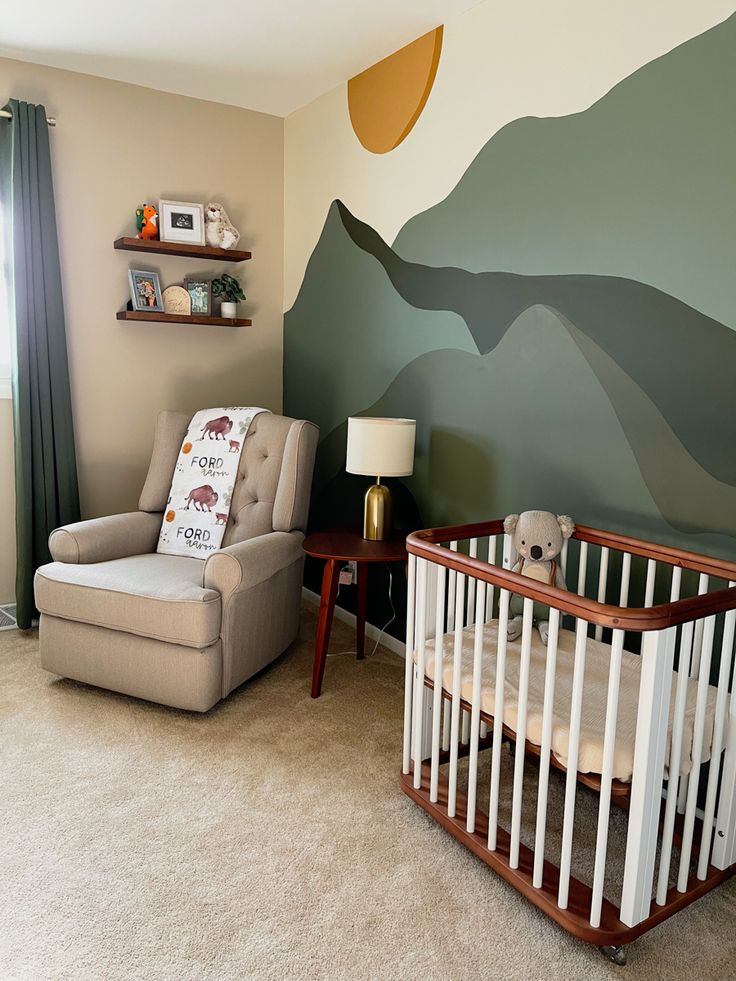 a baby's room with a mountain mural on the wall and a rocking chair