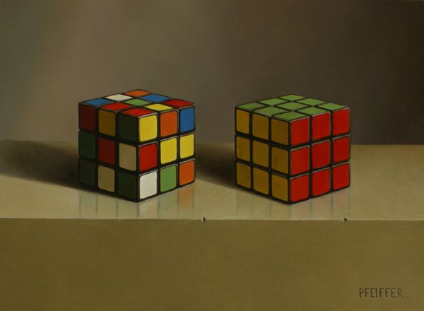 two rubik cubes sitting side by side on a table