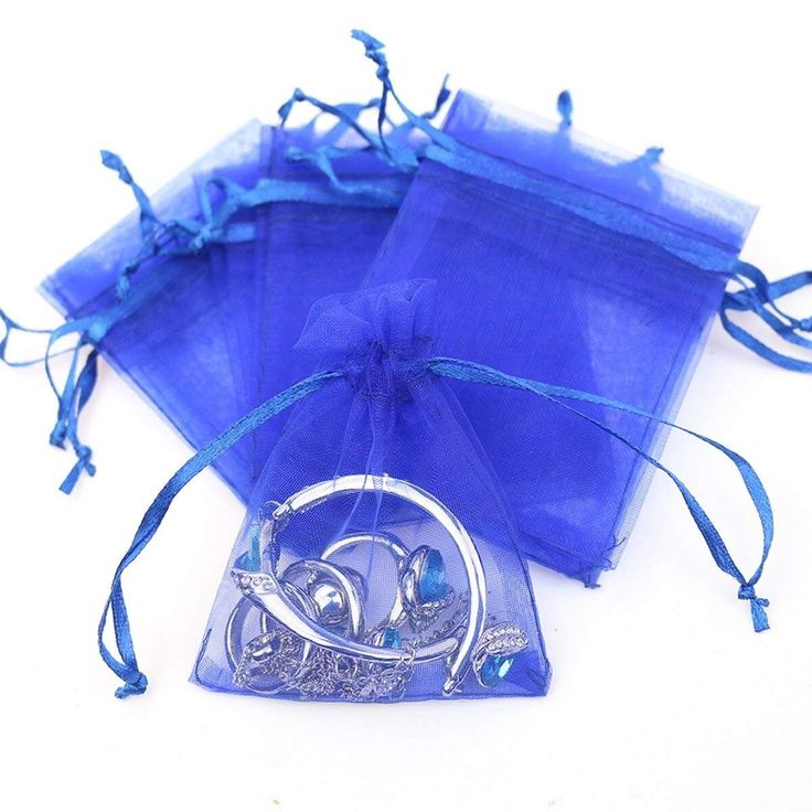 three bags with blue organes and silver rings in them on a white table top