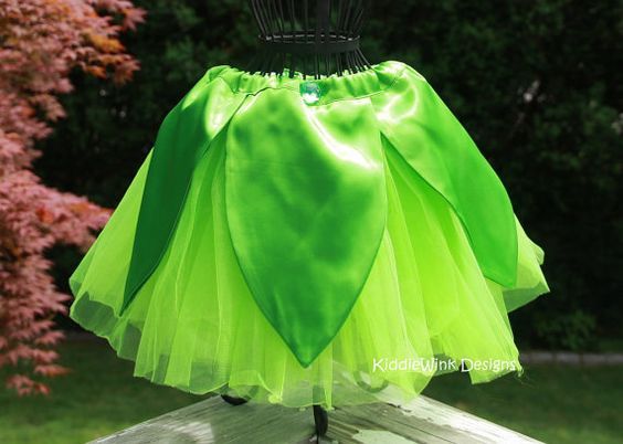 a green tutu skirt on top of a wooden table in front of some trees