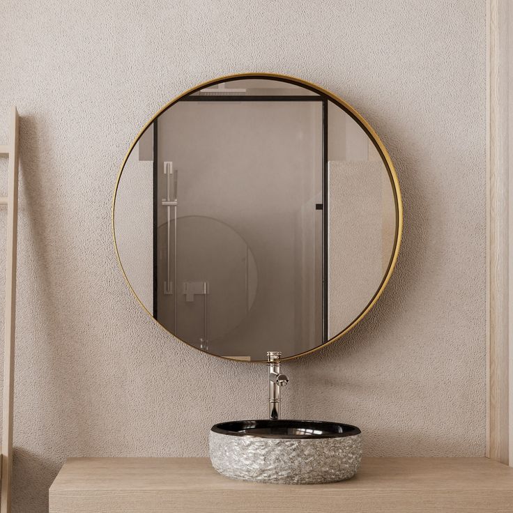 a bathroom with a round mirror above the sink and a black bowl on the counter