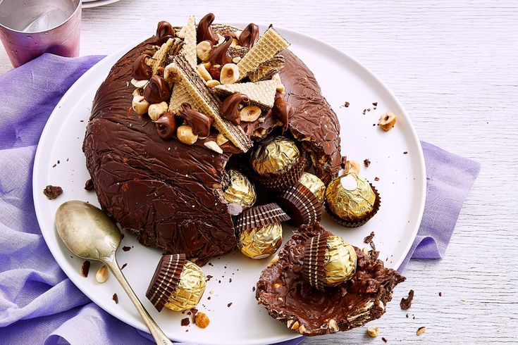 a white plate topped with chocolate covered desserts and toppings next to a spoon