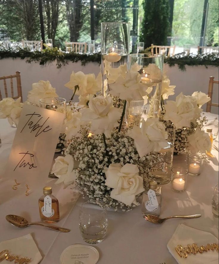 a table with flowers and place settings on it for a formal dinner or wedding reception