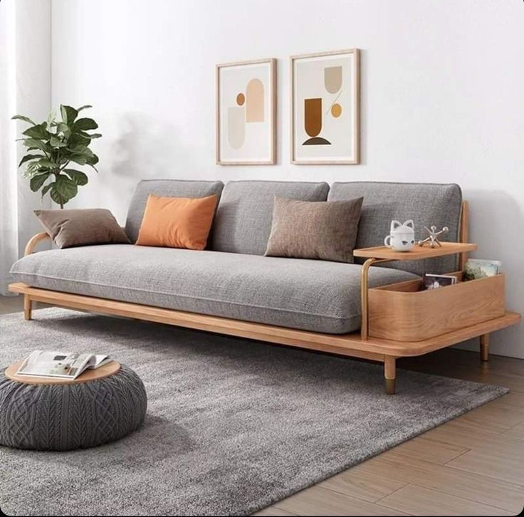 a living room with a couch, coffee table and potted plant on the floor