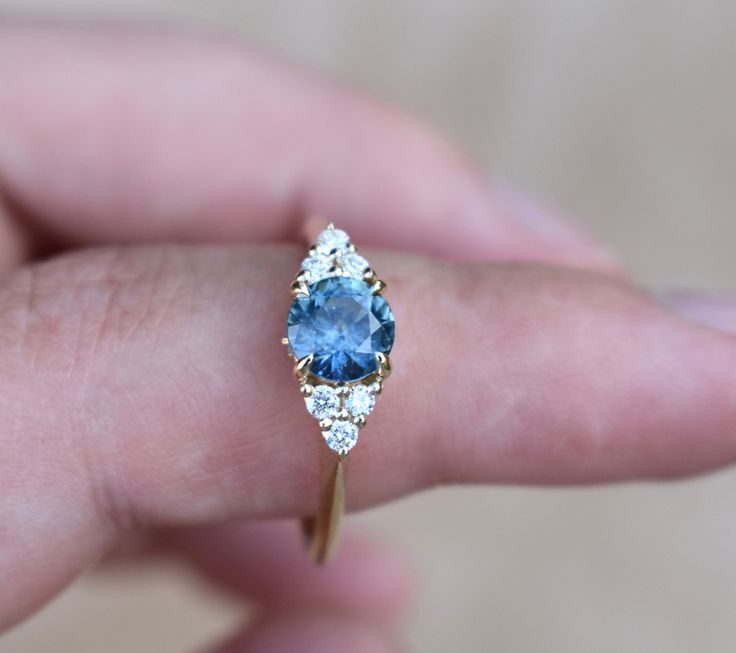 SKY BLUE MONTANA SAPPHIRE RING Once upon a time, the ancient Persians thought sapphires were so special, they believed that the earth had been created on top of the biggest blue sapphire ever, and that's why the sky was blue... It gives so romantic meaning for a blue sapphire engagement ring. One one represents a blue sapphire rig with diamonds to her or his beloved, it's considered representative of sincerity and faithfulness. This nature inspired floral design engagements ring features magic t Heirloom Blue Sapphire Diamond Ring, 14k Gold Blue Sapphire Ring With Center Stone, Blue Celestial Ring With Center Stone, Celestial Blue Rings With Accent Stones, Blue Celestial Rings With Accent Stones, Blue Celestial Sapphire Promise Ring, Celestial Blue Sapphire Promise Ring, Blue Sapphire Ring Birthstone Fine Jewelry, Fine Jewelry Blue Sapphire Ring Birthstone