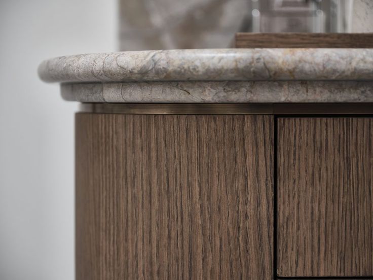 a bathroom vanity with marble top and wooden cabinets