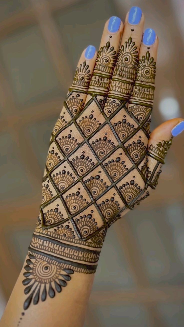 a woman's hand with hennap on it and blue nail polishes