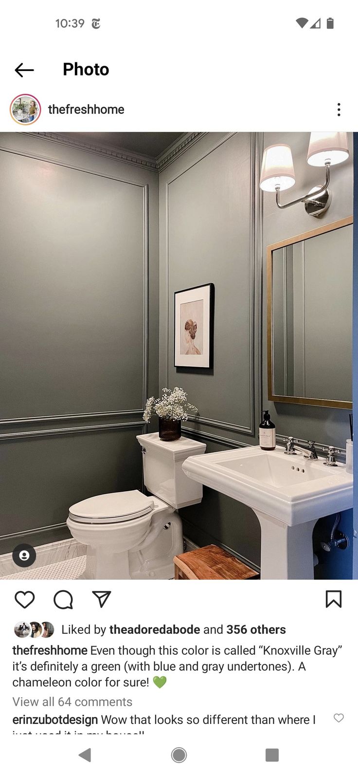 a white toilet sitting next to a sink in a bathroom under a framed photo on the wall