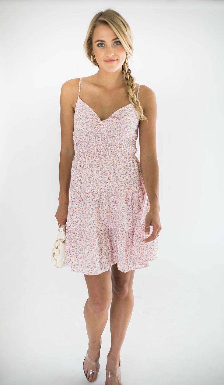 Elevate your look with our Dylan mini dress, a perfect blend of elegance and summer fun. This dress features a flattering twist front design and playful tiered layers. It has adjustable spaghetti straps that ensure a personalized fit, while the smocked back provides comfortable stretch and support. Ideal for both casual outings and special occasions, this mini dress is your go-to choice for a chic and effortless look. Size Chart Features: mini length twist front v-neck design smocking adjustable spaghetti straps lined fabric content: 100% polyester model is wearing a small. Height 5'7" Bust 34", Waist 25", Hip 36" Denim Accessories, Purse Strap, Elevate Your Look, Twist Front, Dress Romper, Front Design, Neck Designs, Bottoms Pants, Short Tops