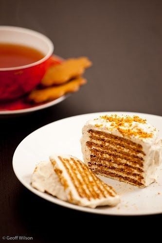 a piece of cake on a plate next to a cup of tea and crackers