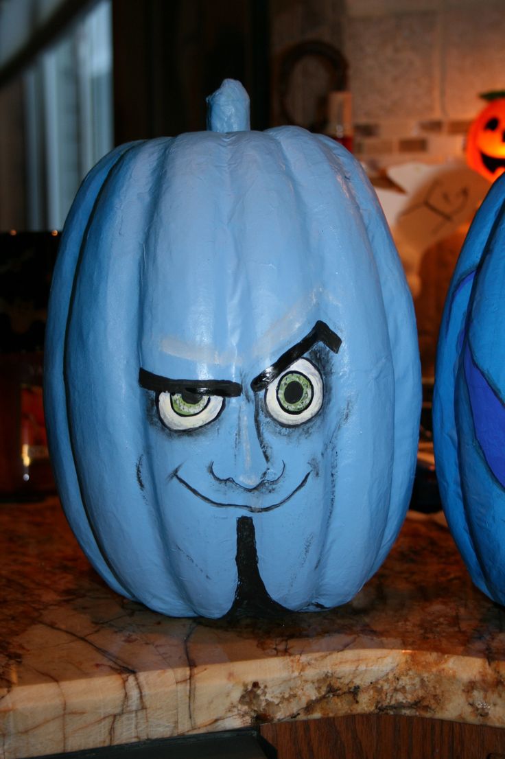 two blue pumpkins with faces painted on them