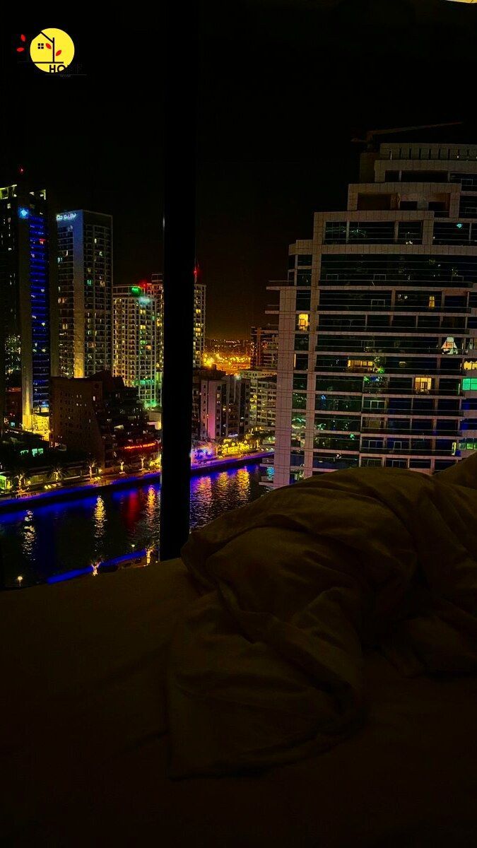 the city lights shine brightly in the night sky from this bedroom window overlooking the river