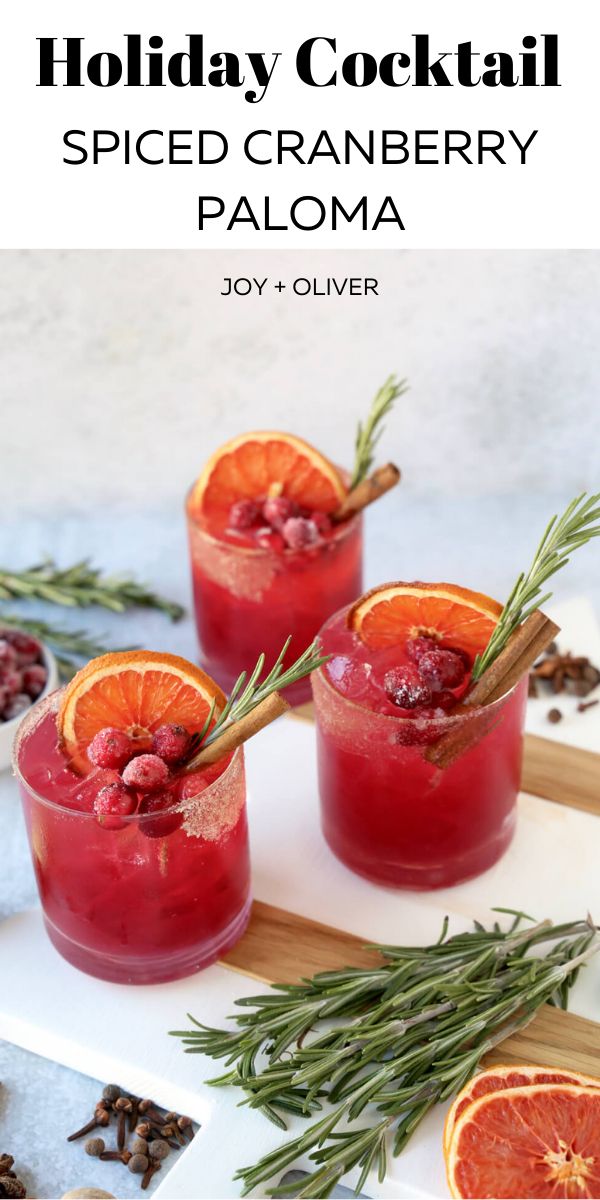 holiday cocktail with spiced cranberry paloma and rosemary garnishes