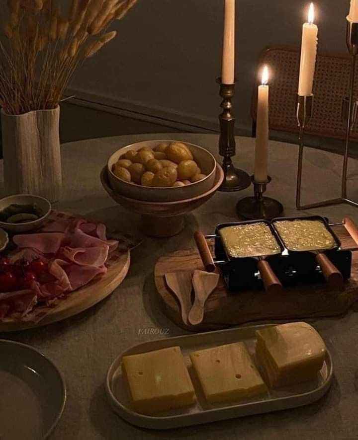 a table topped with lots of food next to candles and plates filled with food on top of a table