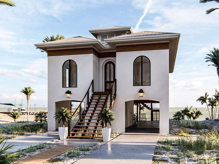 a white house with stairs leading up to the front door and second story balcony area