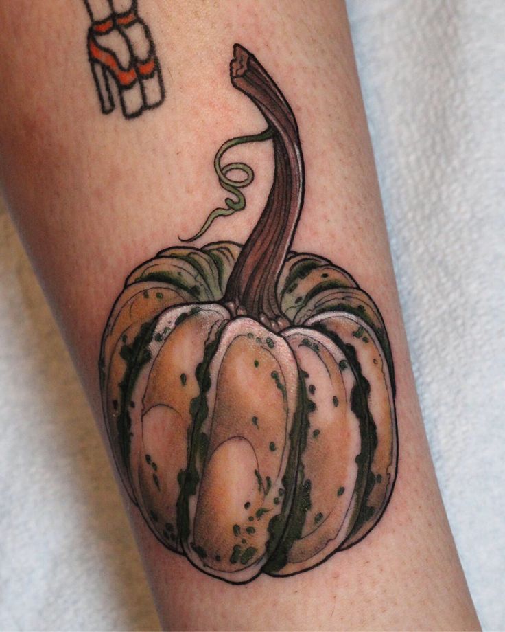 a tattoo with a pumpkin on the arm