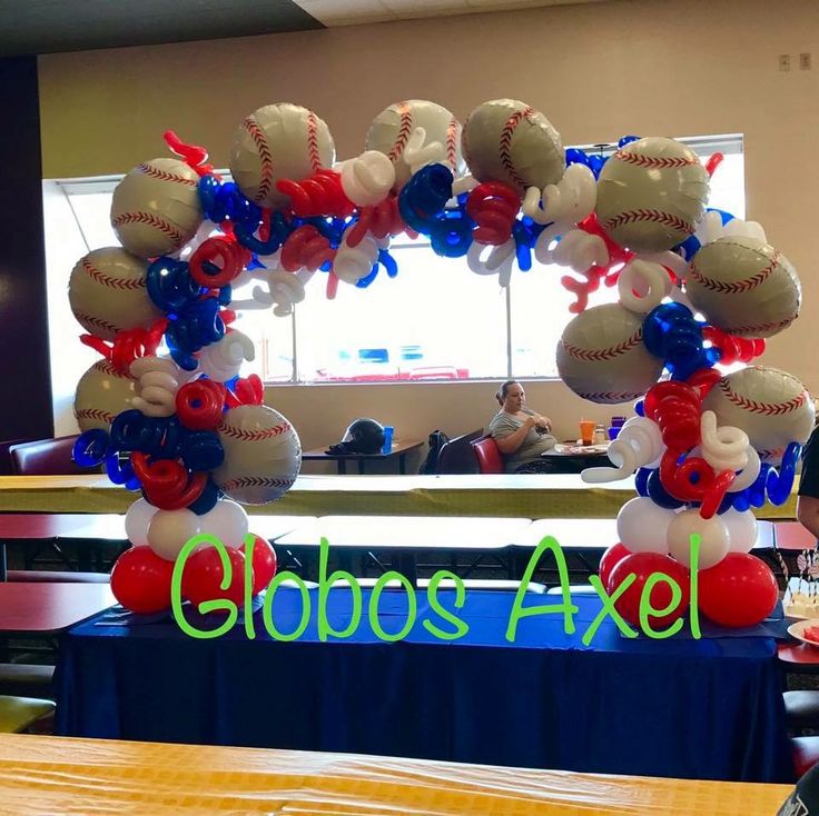 an arrangement of balloons and baseballs on a table