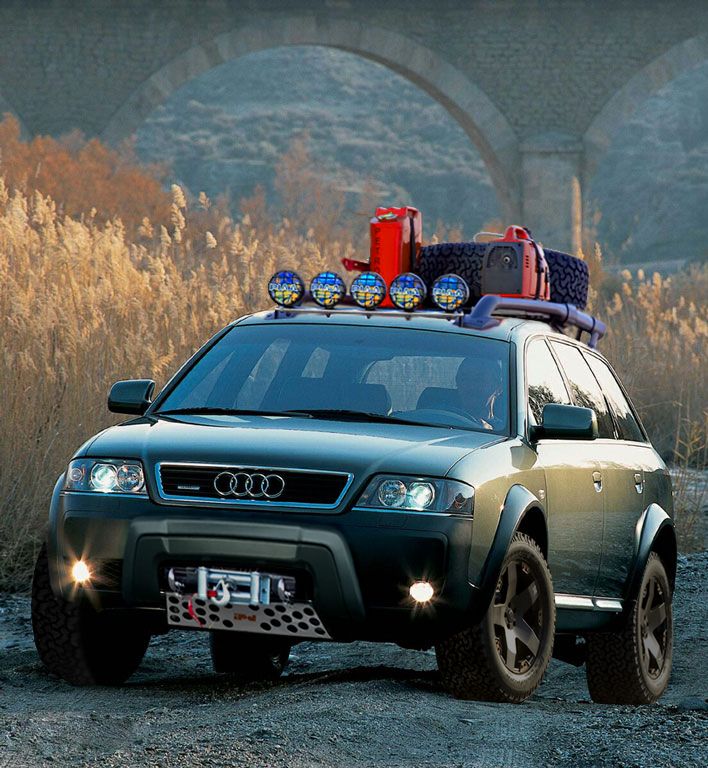 an suv with luggage on top is parked in the dirt